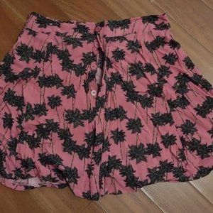 Palm trees mini skirt opening with buttons.